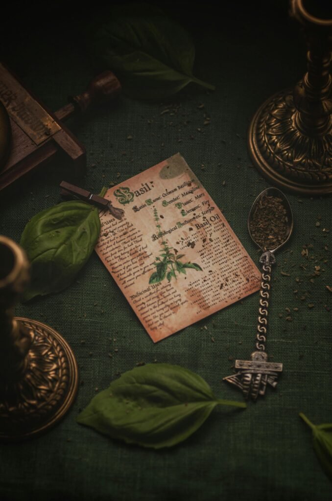 A flat lay featuring a vintage basil recipe card surrounded by fresh basil leaves.